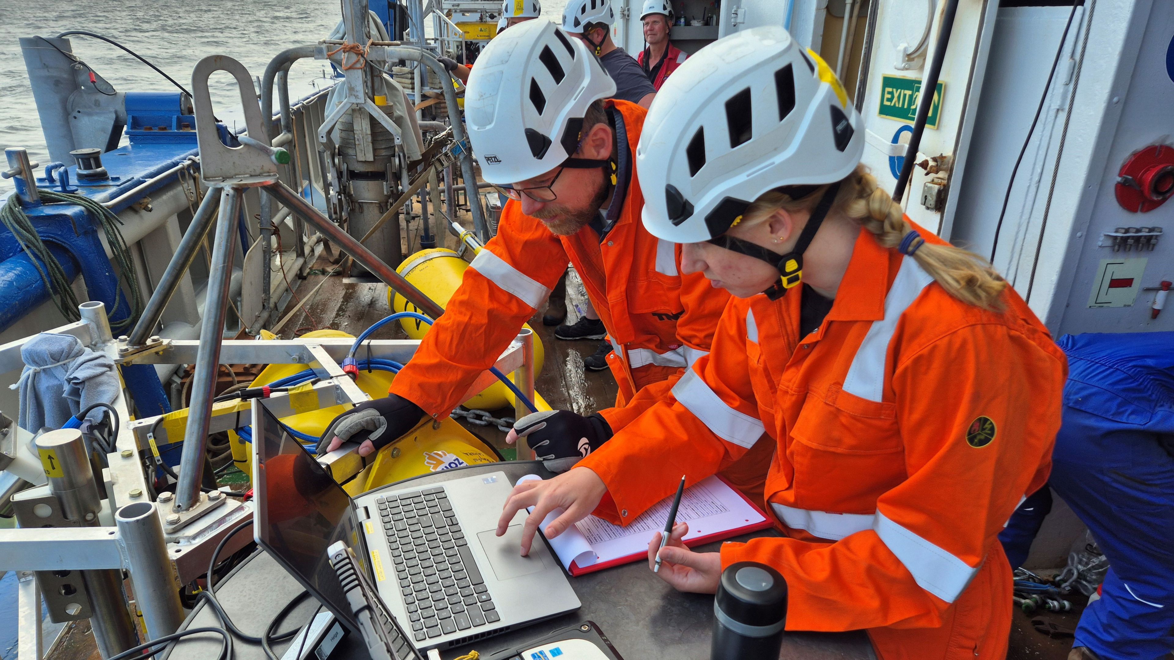 Photo of two scientists on deck of a research vessel