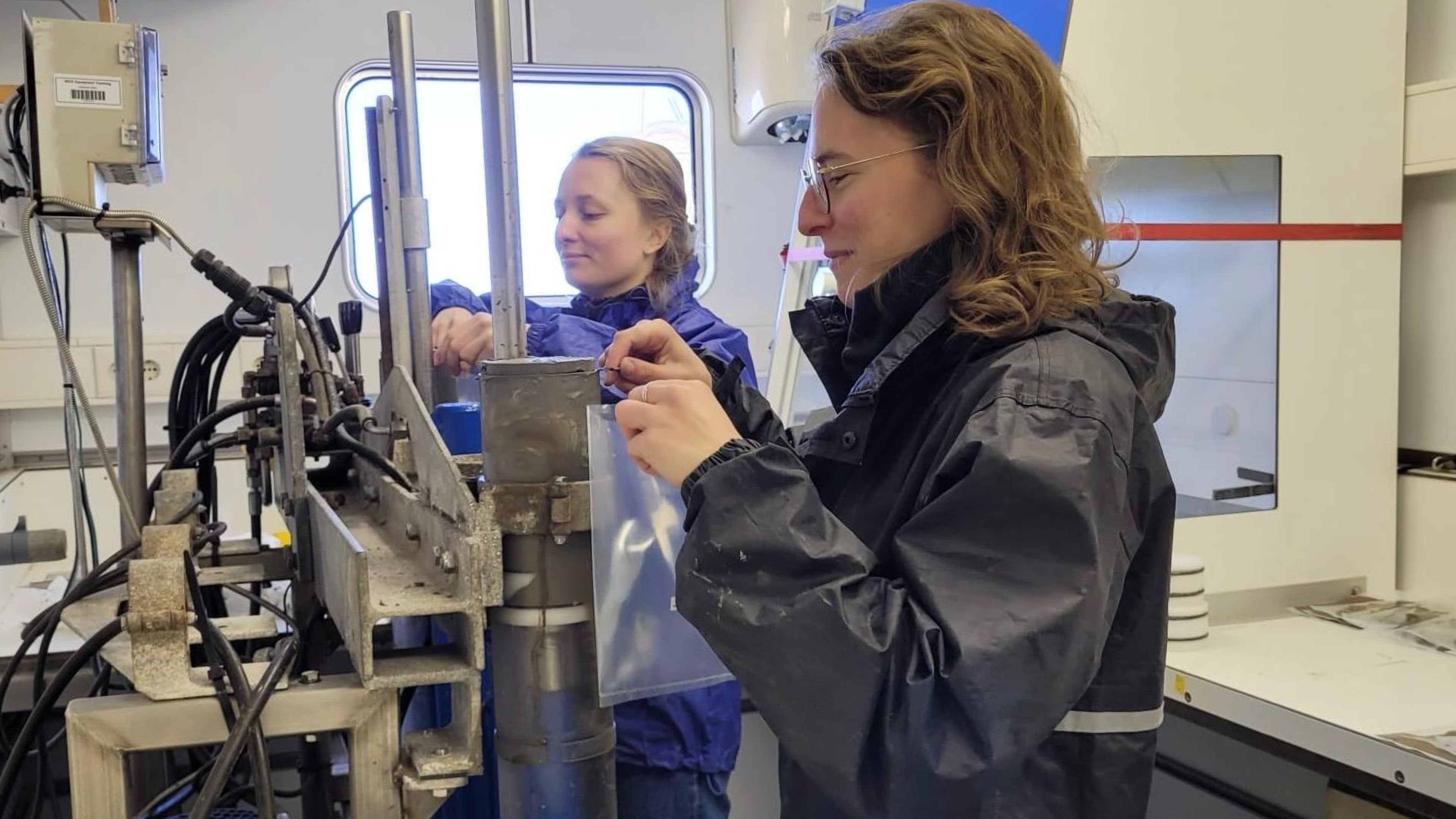 Two women slicing sediment cores in the laboratory on board of a research vessel on the 2nd North-Sea Atlantic Exchange expedition