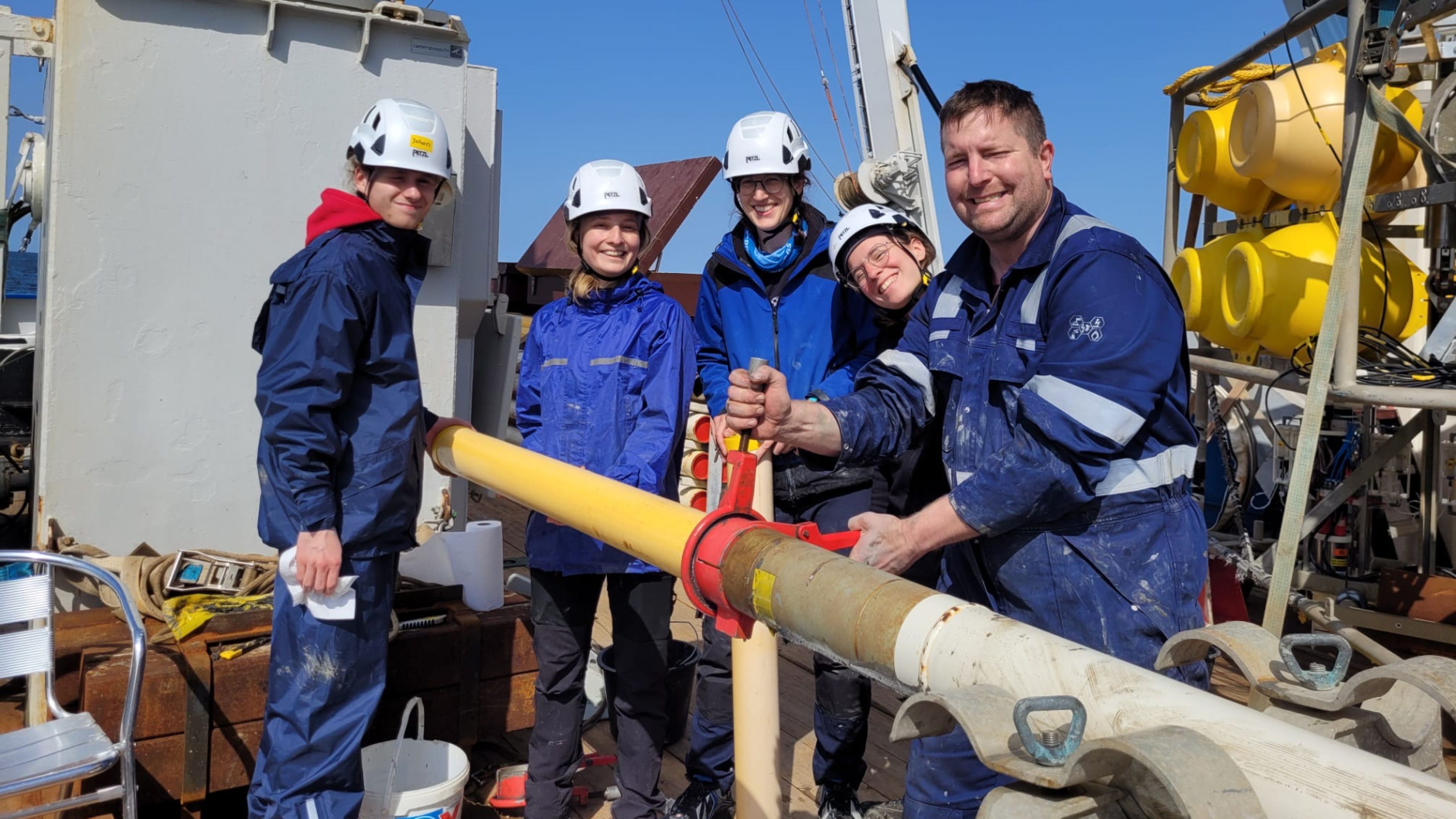 Several people on deck of a research vessel with a piston core that is cut into 1 m sections on the 2nd North-Sea Atlantic Exchange expedition