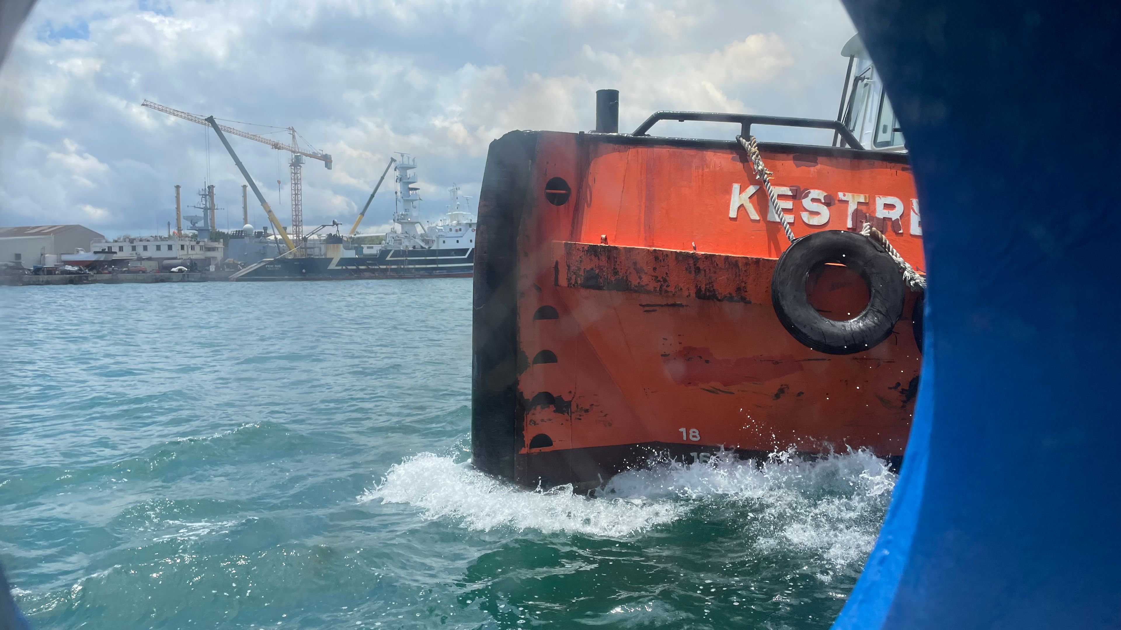 Photo of a ship with a harbour in the background