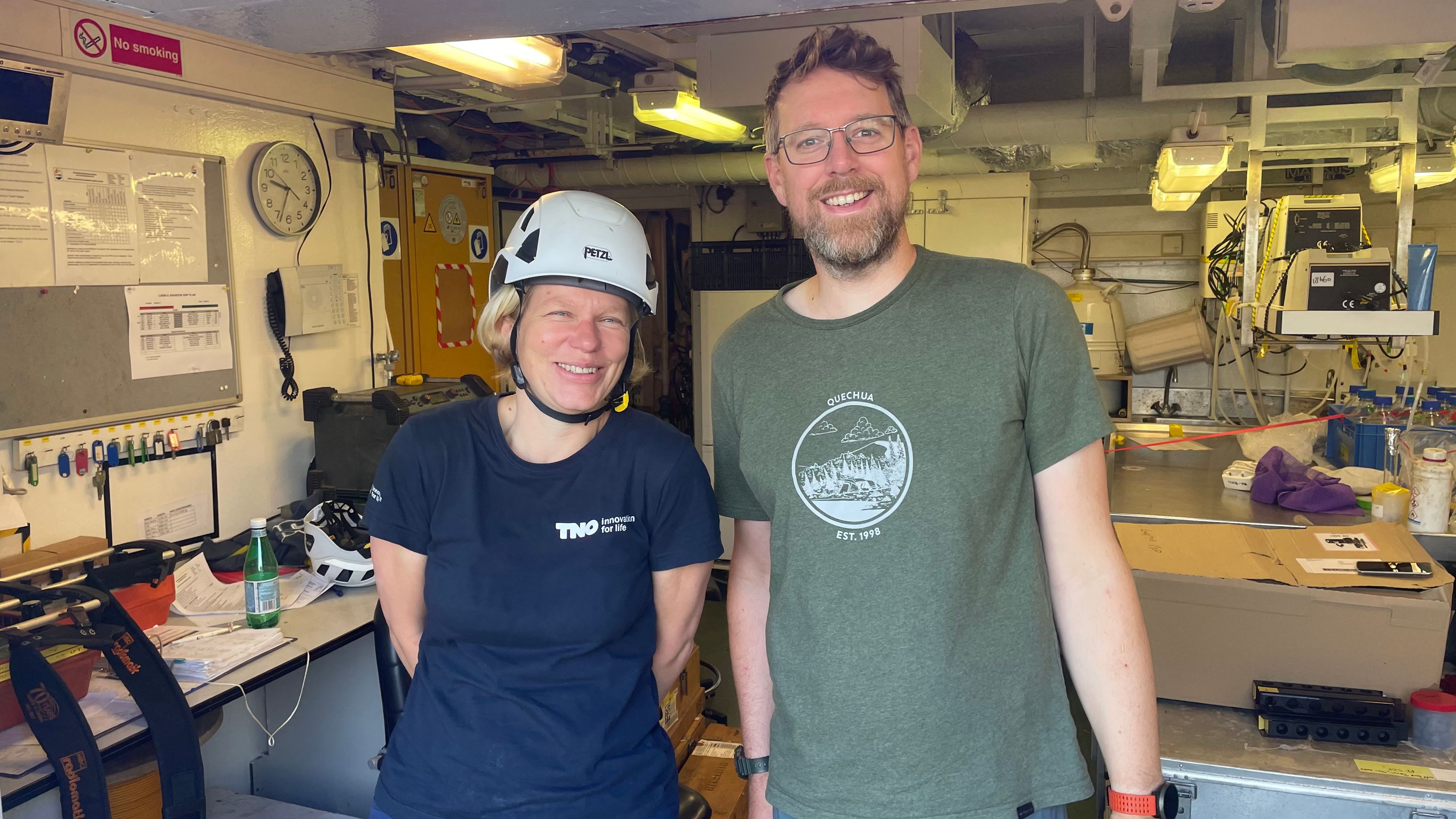 Photo of two researchers, one wearing a helmet