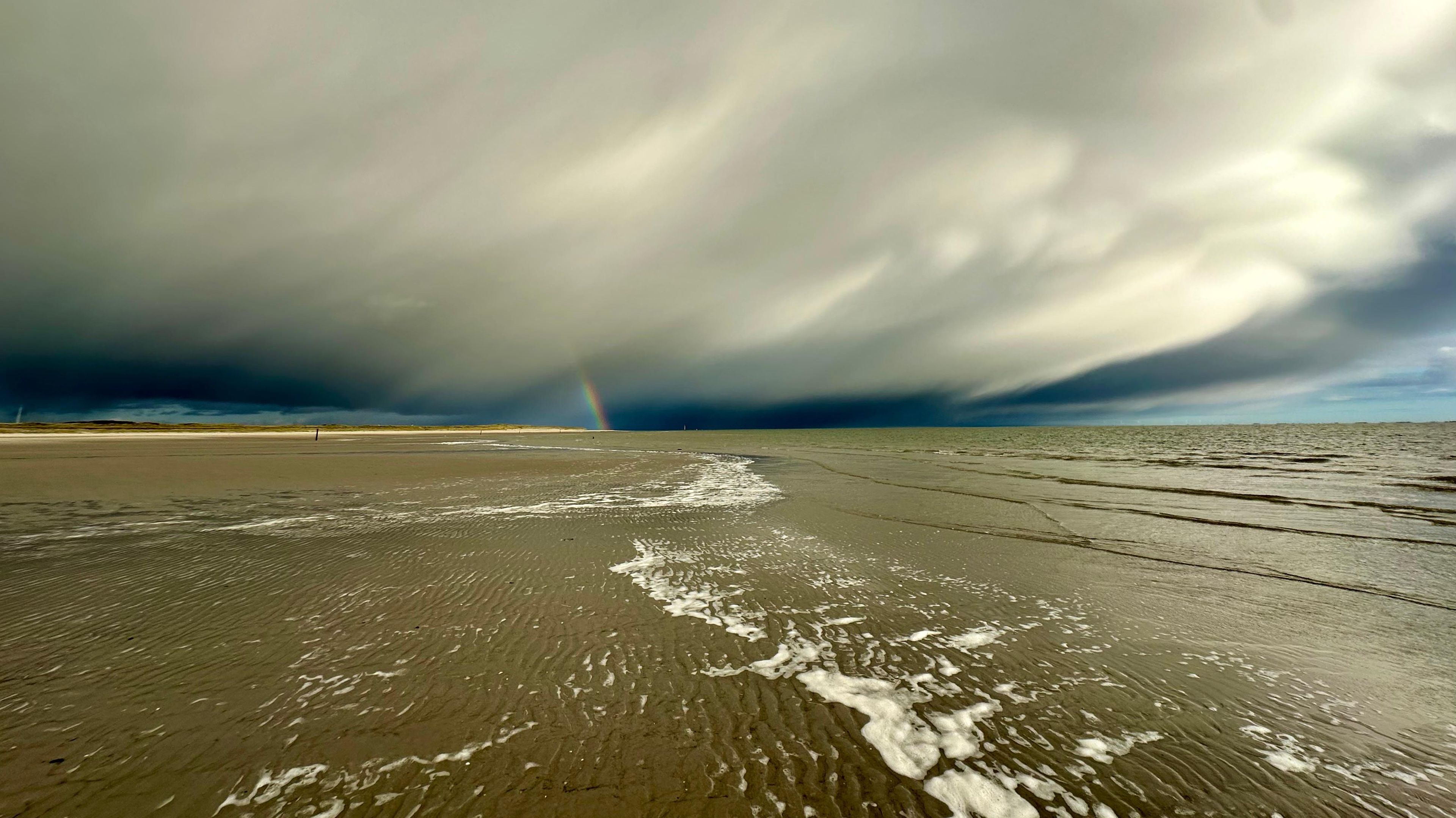 Photo of rainbow with clouds and sand, Hors