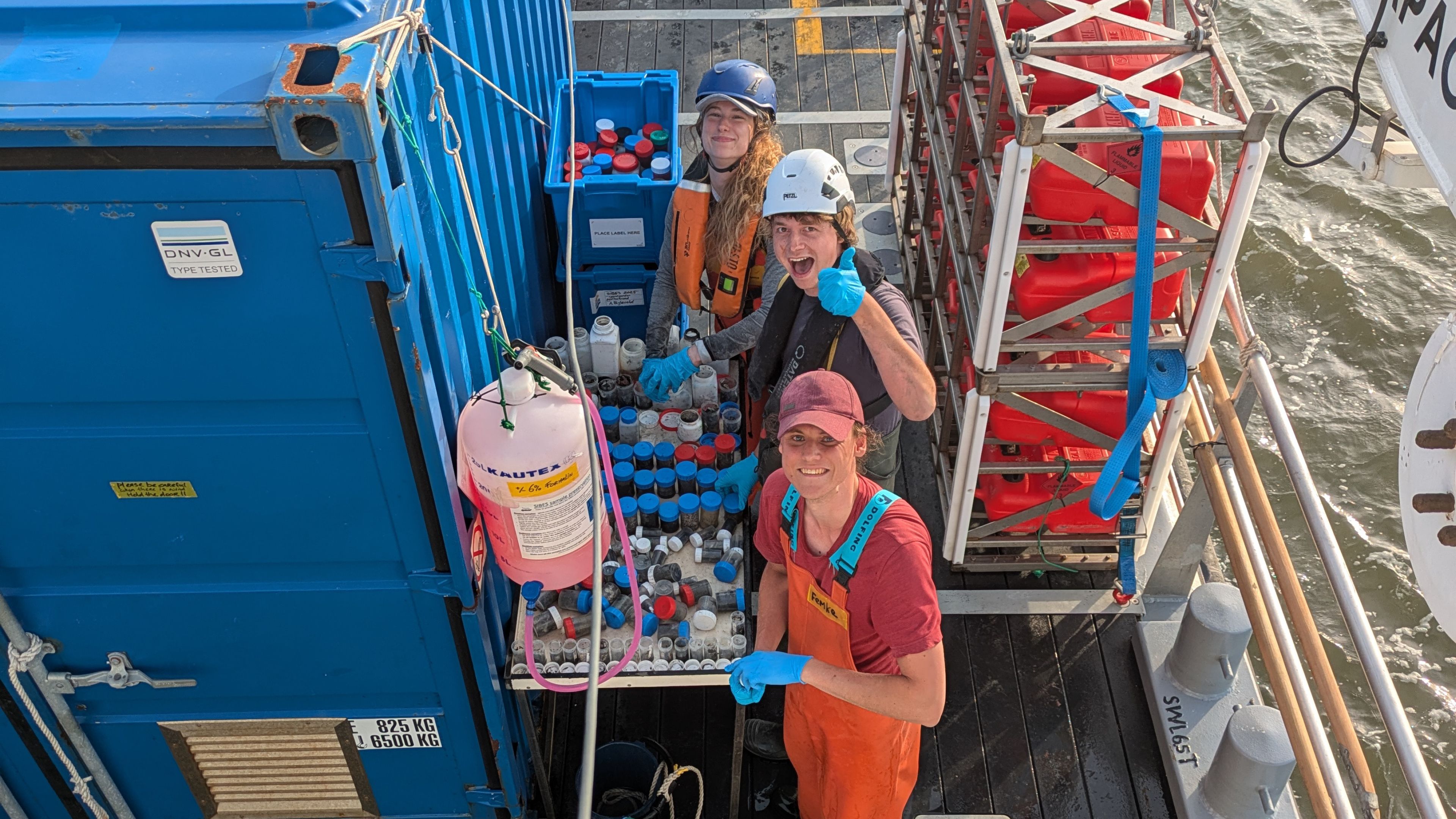 Three people processing samples after a SIBES sampling session on board of a research vessel in the Wadden Sea